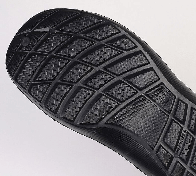 Close-up of the tread pattern on the sole of a black EVA quick-dry clog, showcasing durable grip design for men's casual beach shoes.
